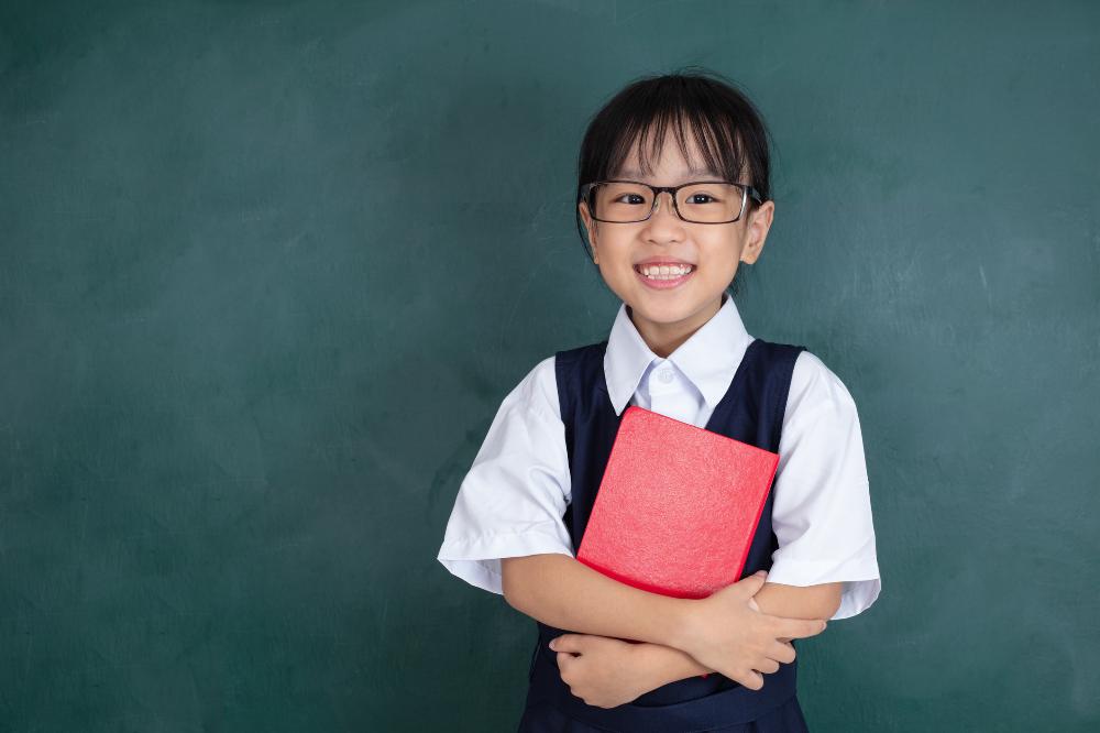 girl holding pink book blue background.jpg