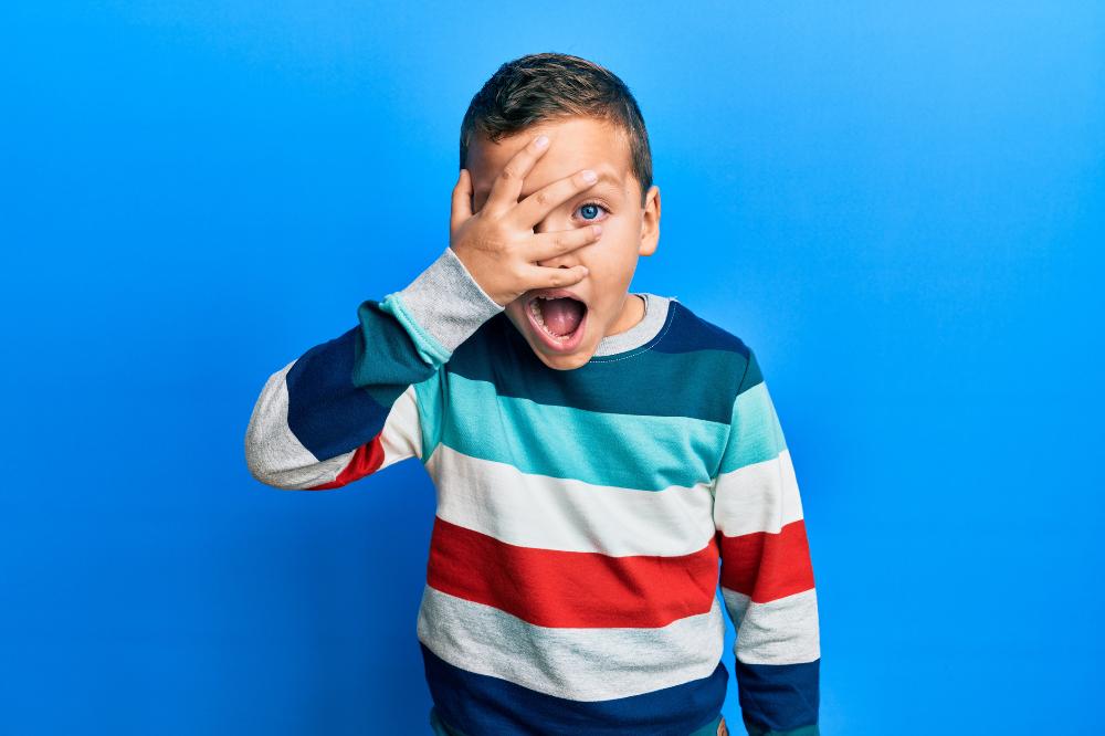 Boy in striped shirt covering eye.jpg
